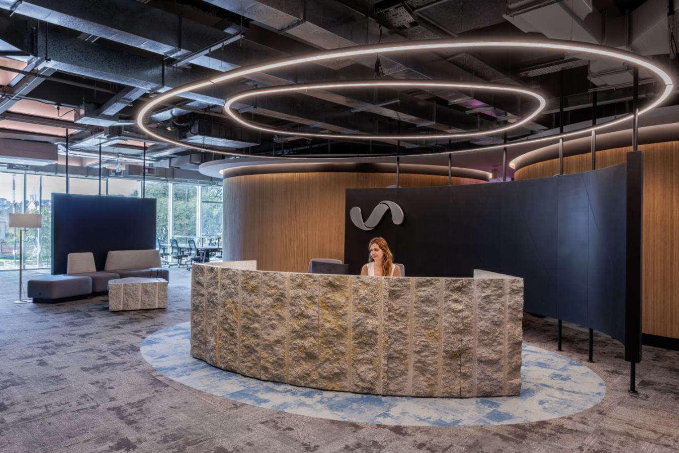 Uala Offices 2024 - Modern reception area with circular light fixtures and textured stone desk - Contract Workplaces.jpg